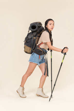 Donna escursionista a piedi con bastoncini da trekking