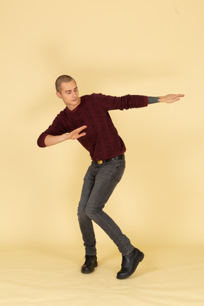 赤いプルオーバーで踊っている若い男の正面図