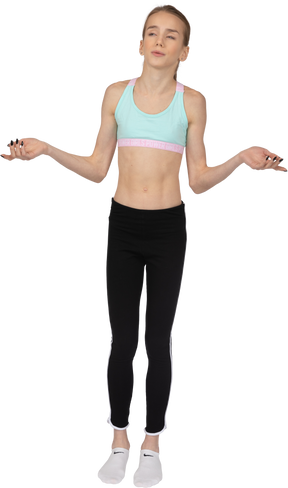 Vista frontal de uma adolescente em roupas esportivas levantando as mãos e raciocinando