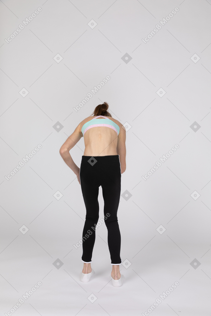 Back view of a teen girl in sportswear bending over