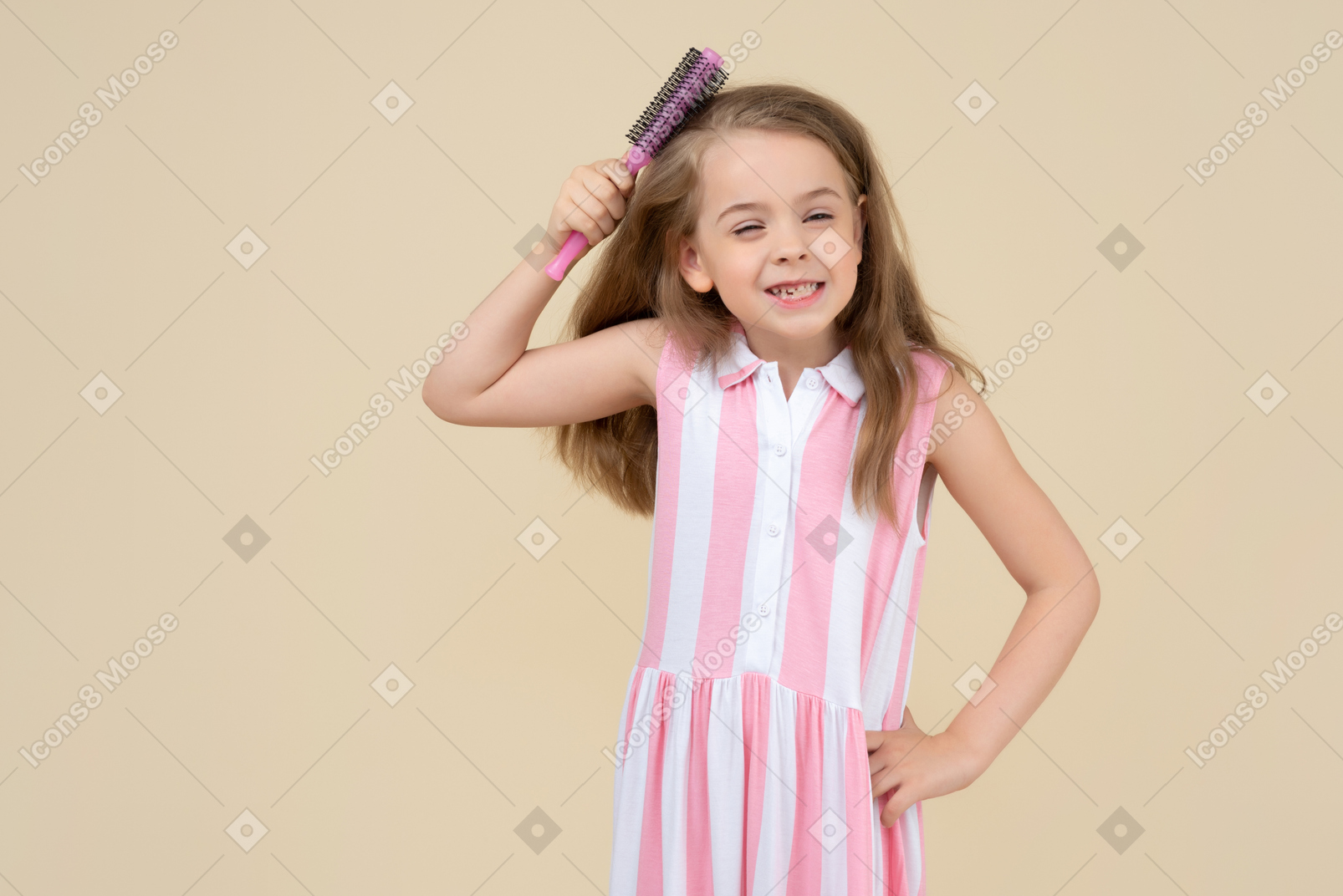 Cute little girl trying to brush her hair