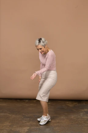 Side view of a woman in casual clothes making welcoming gesture