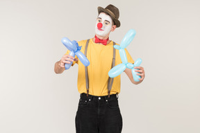 Male clown holding balloon figures