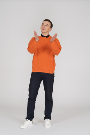 Young man in orange sweatshirt standing