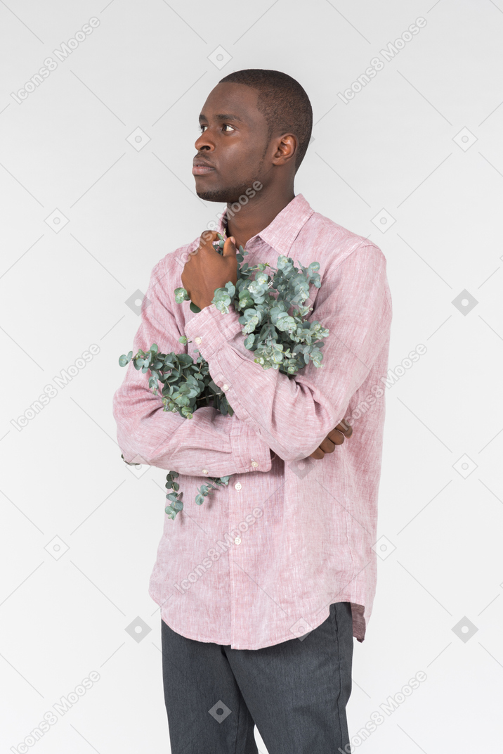 Good looking young man holding flowers