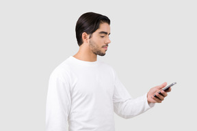 Handsome young man looking at something on his phone
