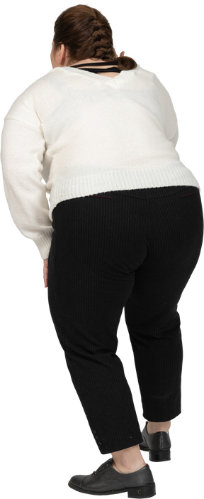 Vista posteriore di una donna grassoccia che si china