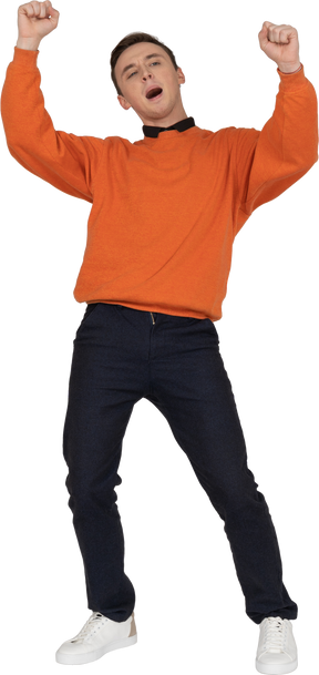 Молодой человек в оранжевой толстовке танцует