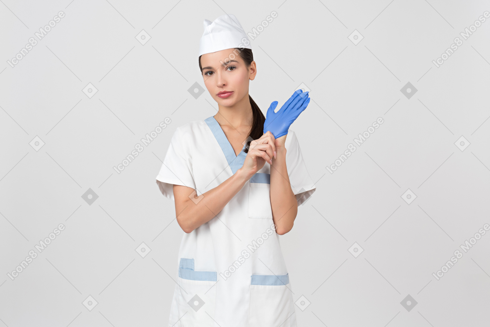 Enfermeira atraente em um manto médico colocando uma luva de látex