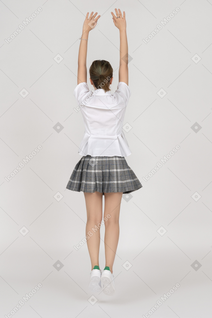A young girl stretching up in a jump