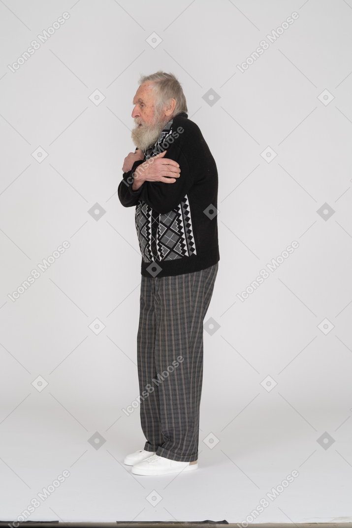 自分を抱きしめる老人の側面図