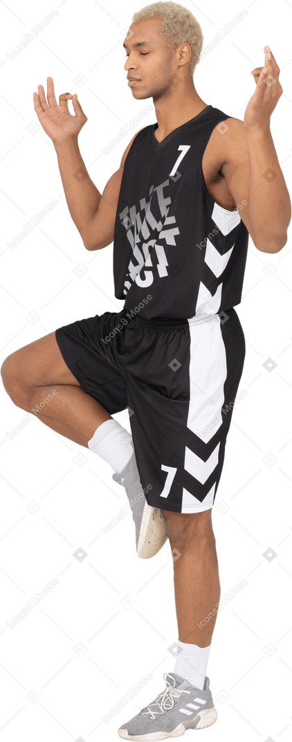 Three-quarter view of a meditating young male basketball player