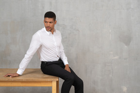 Man in office clothes sitting on a table