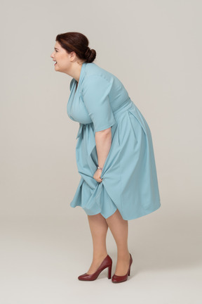 Woman in blue dress posing in profile