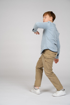 A young boy swinging his arms while walking