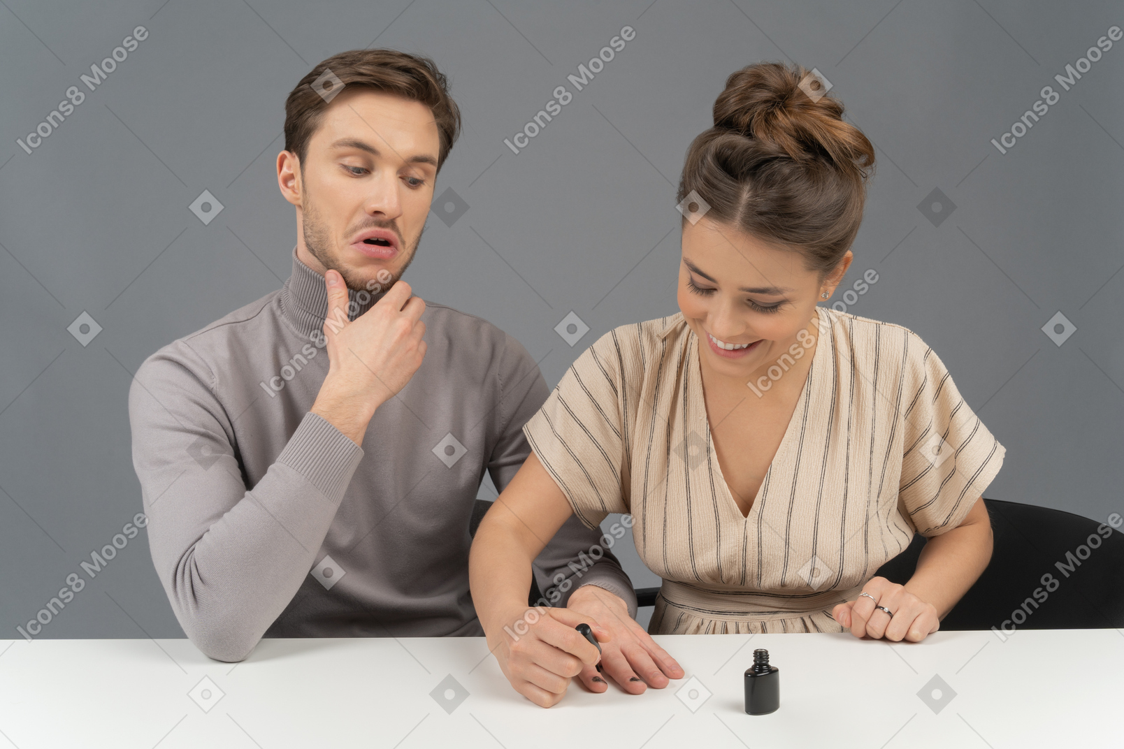 Cheerful young woman polishing her husband`s nails