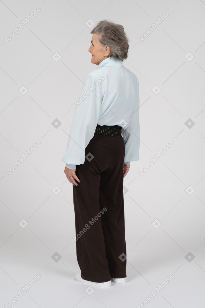 Vista posteriore di una donna anziana che sorride dolcemente a sinistra