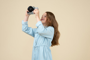 Bambina carina che tiene una macchina fotografica