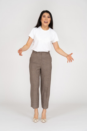 Front view of a complaining young lady in breeches and t-shirt outspreading her hands