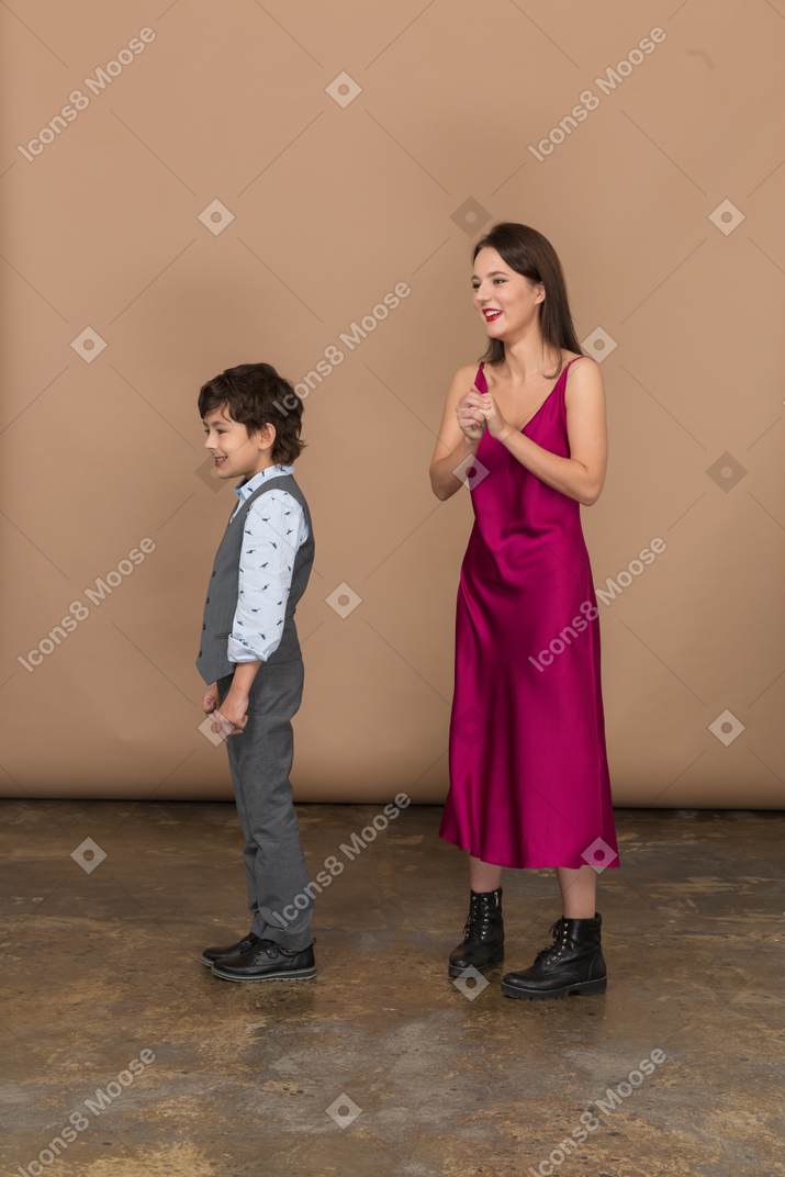 自分の手を握っている女性と彼女の近くに立っている男の子