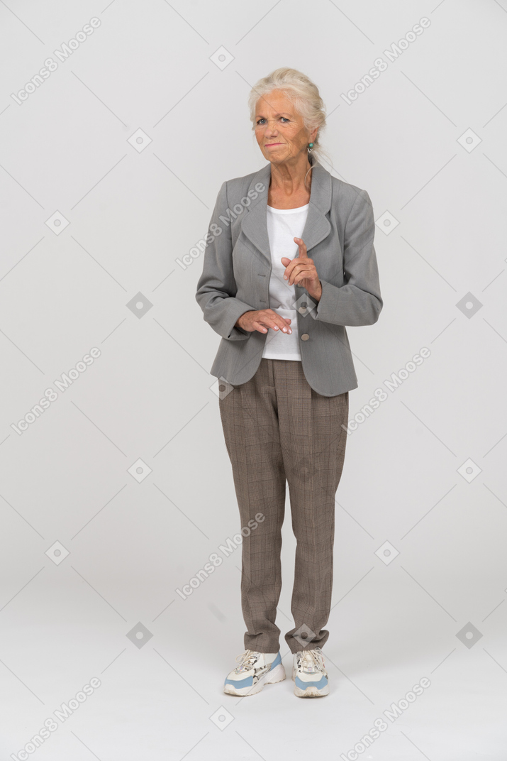 Front view of an old lady in suit showing a warning sign