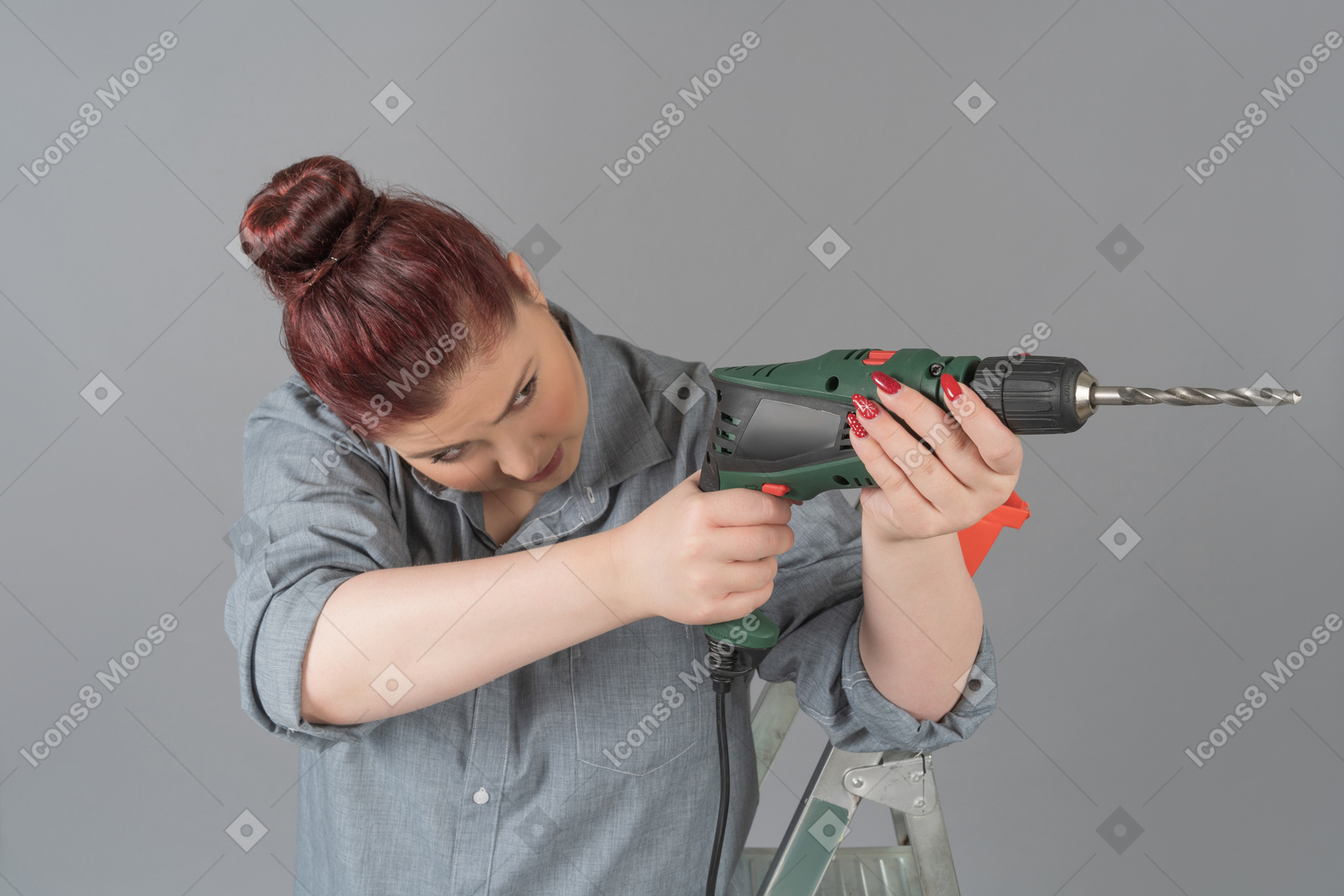 Concentrated woman aiming with a drill