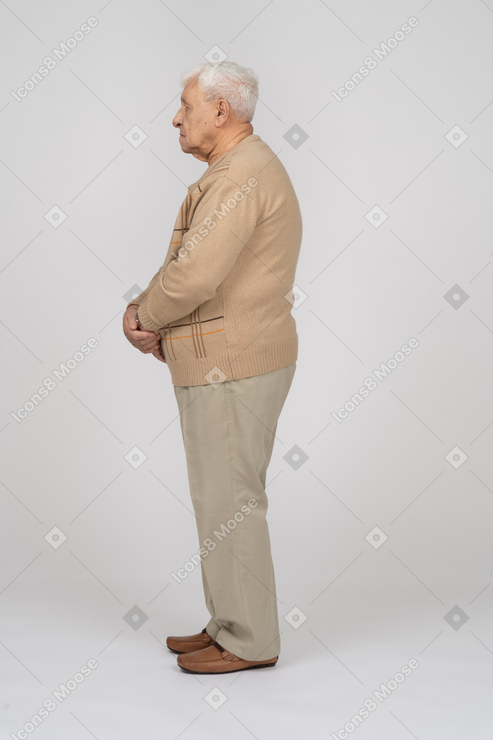 Old man in casual clothes standing in profile
