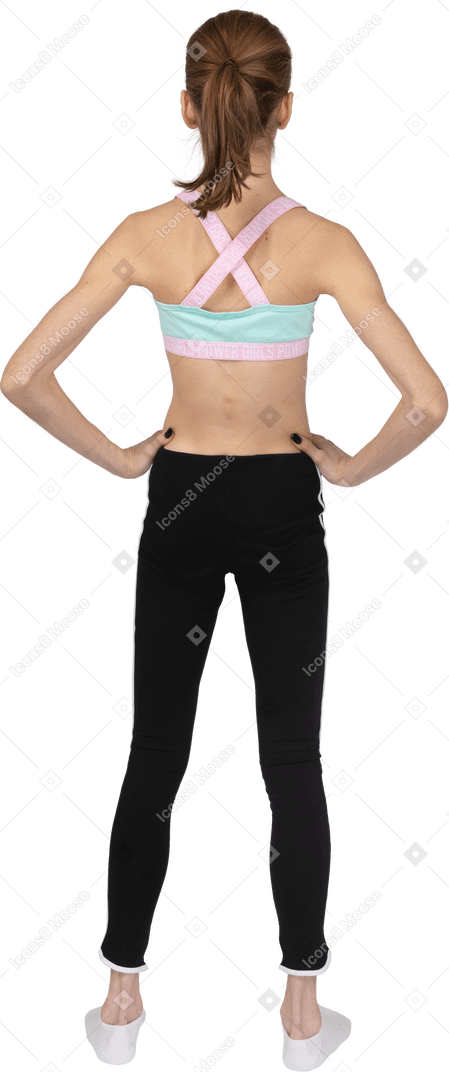 Vista posteriore di una ragazza adolescente in abiti sportivi che mette le mani sui fianchi