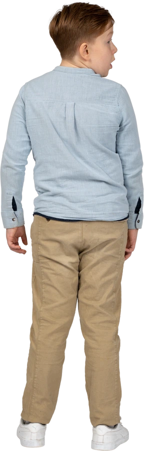 Back view of an impressed boy looking aside