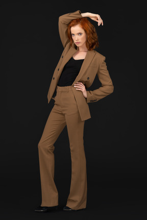 A woman in a brown suit posing for a picture