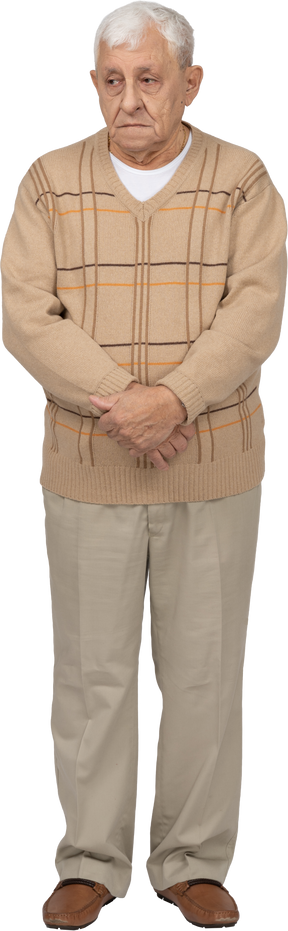 Front view of an old man in casual clothes standing still with his eyes closed