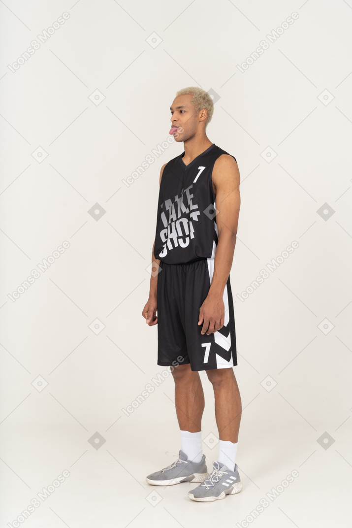Three-quarter view of a young male basketball player showing tongue