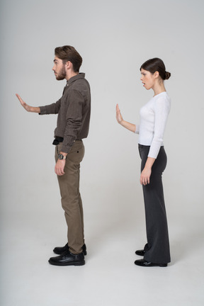 Vista posteriore di tre quarti di una giovane coppia in abiti da ufficio che tende la mano