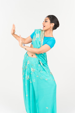 Jeune femme indienne en sari bleu debout en position de danse