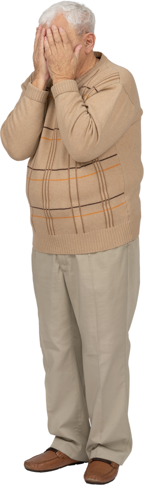 Vista frontale di un vecchio in abiti casual che coprono il viso con le mani