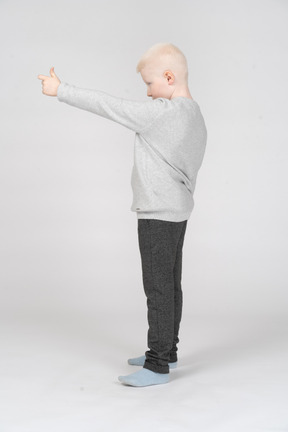 Side view of boy showing thumb up