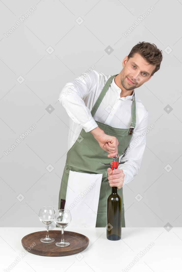 Young sommelier opening a bottle of wine
