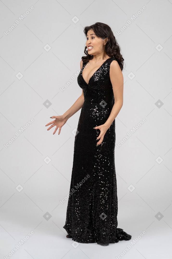 Beautiful angry woman in black evening dress ready to tear somebody to pieces