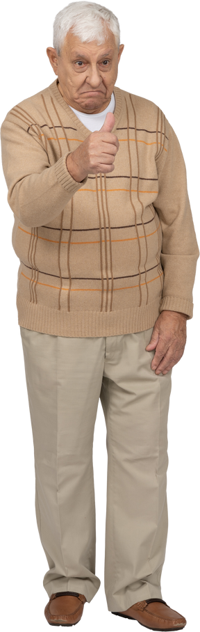 Vista frontal de un anciano con ropa informal que muestra el pulgar hacia arriba