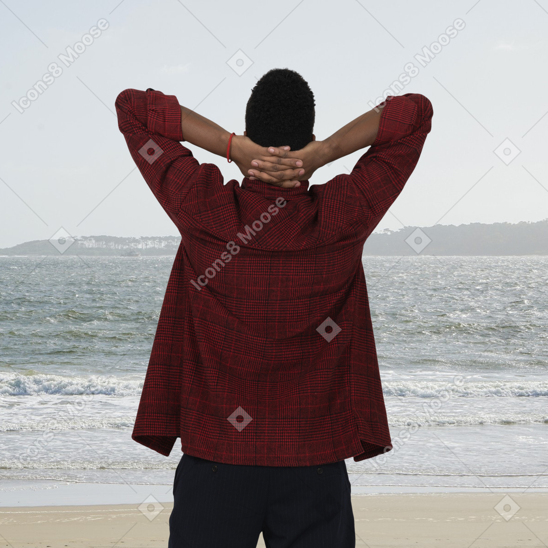 Vista posteriore di un uomo che guarda il mare