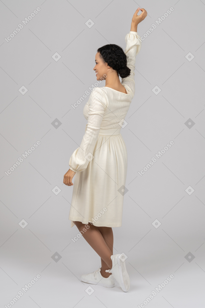 Excited young woman holding one hand up