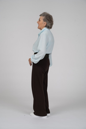 Vista lateral de una anciana haciendo muecas a la izquierda