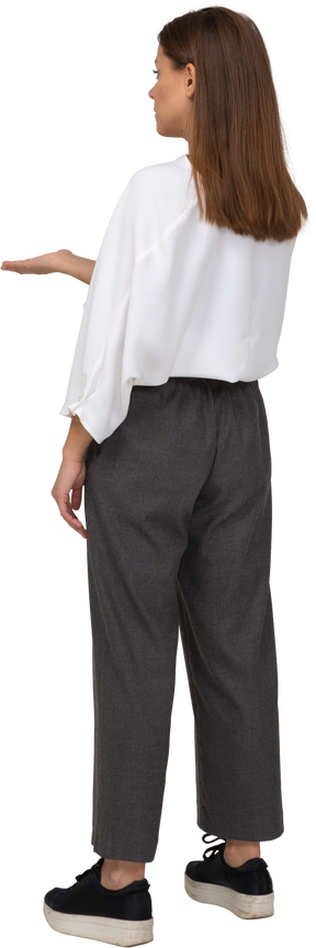 Three-quarter back view of a young lady in office clothing asking for something