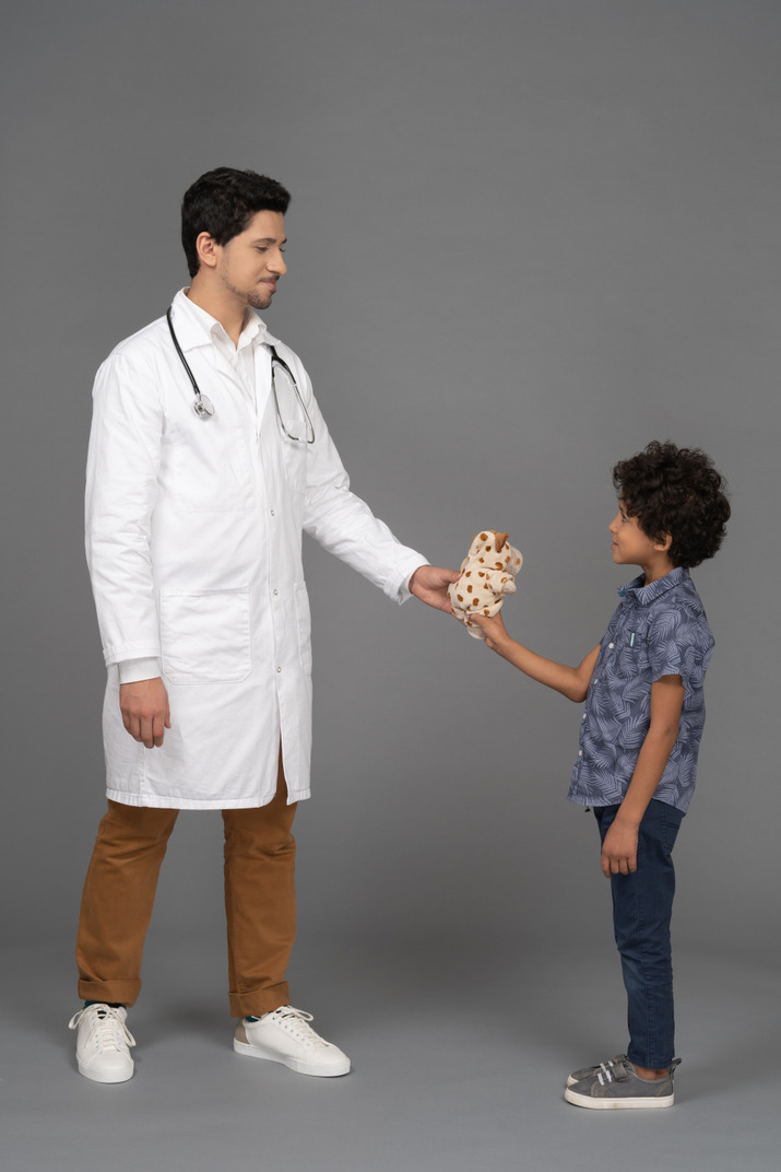 Doctor giving a toy to little kid