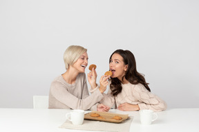 Giovani donne che si nutrono a vicenda con i biscotti