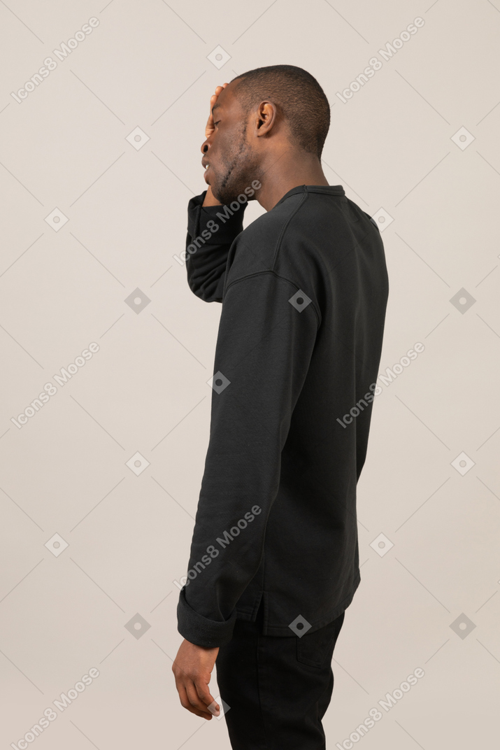 Side view of a man touching forehead