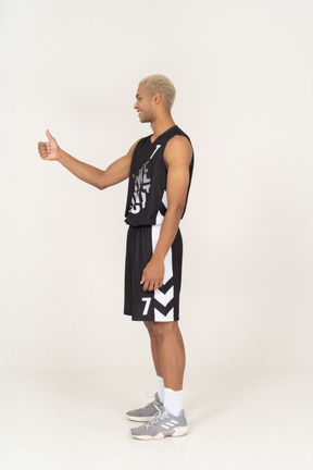 Seitenansicht eines jungen männlichen basketballspielers mit daumen nach oben