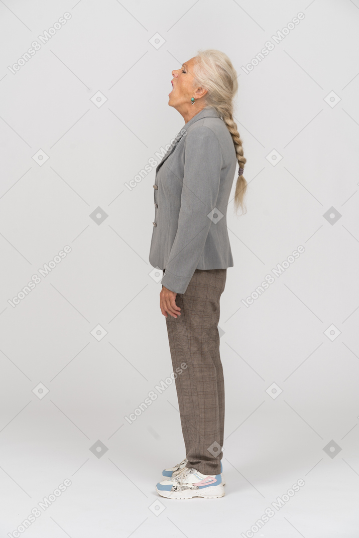 Side view of a sleepy old lady in suit yawning