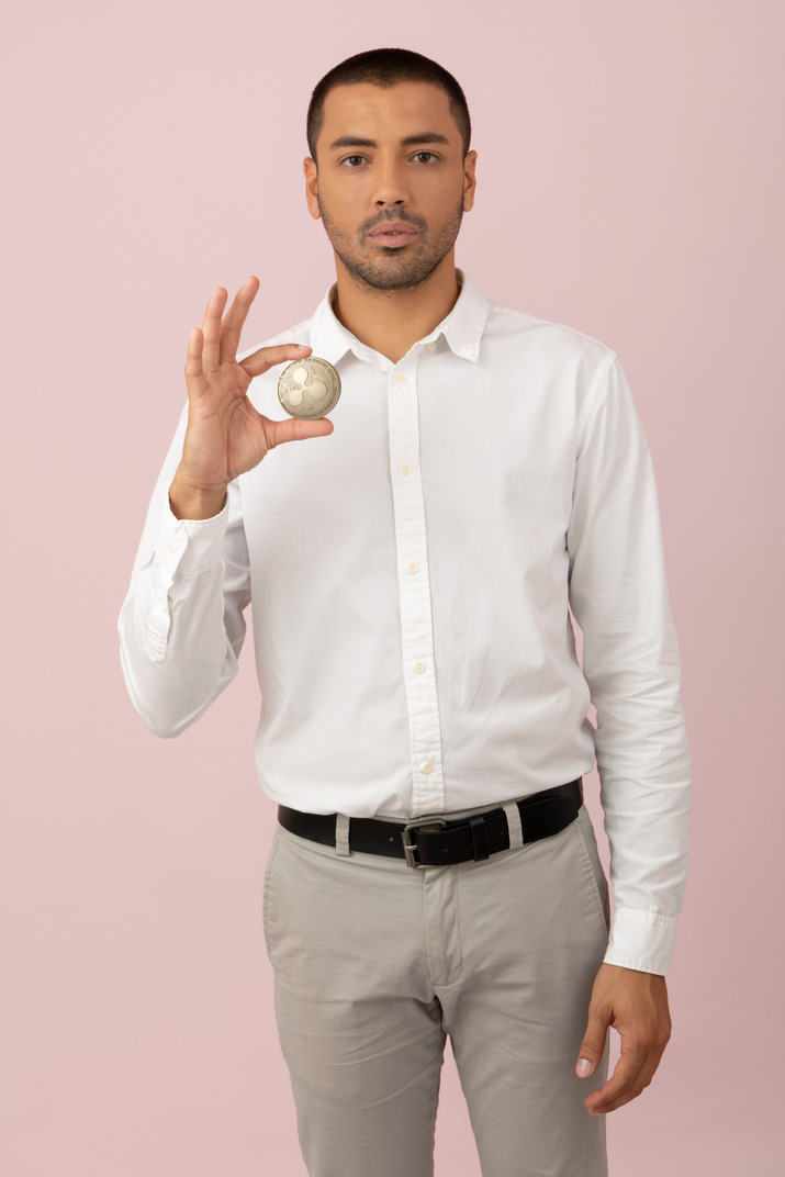Young handsome man holding a ripple coin