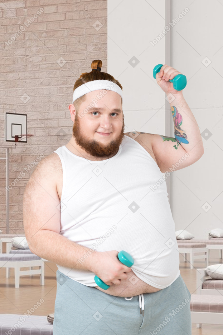 A fat man holding a pair of green dumbs